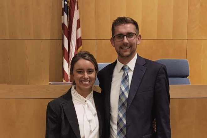 Two people standing in a court room. 