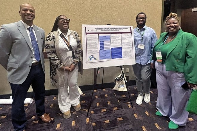 Group standing around a display board. 