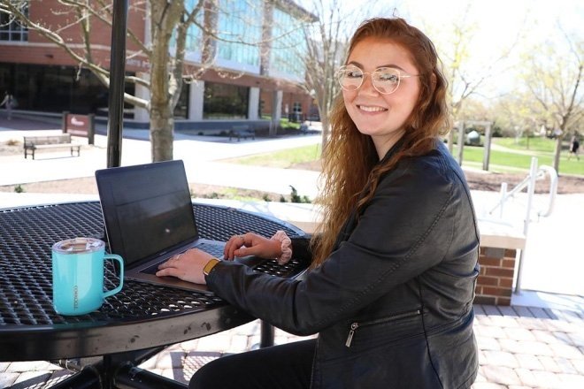 a photo of Emily Jackson '22 on her computer outside