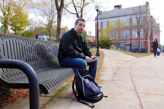 Commonwealth University - Bloomsburg student Jeremy Dilliplane sits on a campus bench