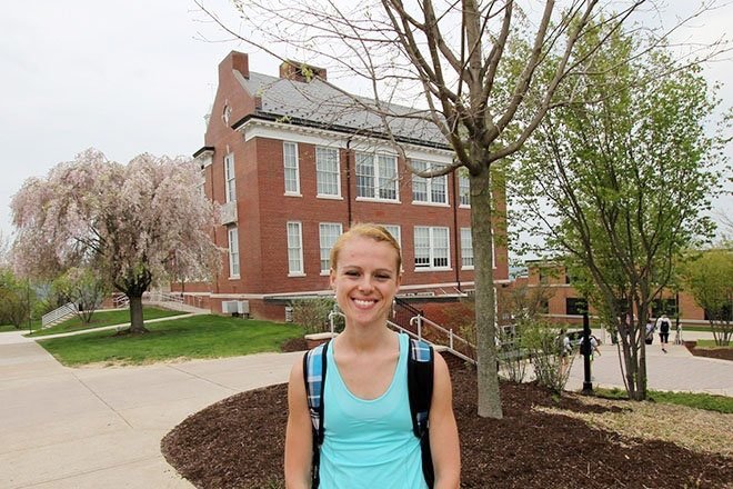 Commonwealth University - Bloomsburg student Riley Renn stands in front of a tree on campus