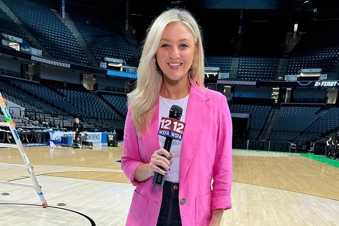 Rosie Langello presenting as a broadcaster at a basketball court.