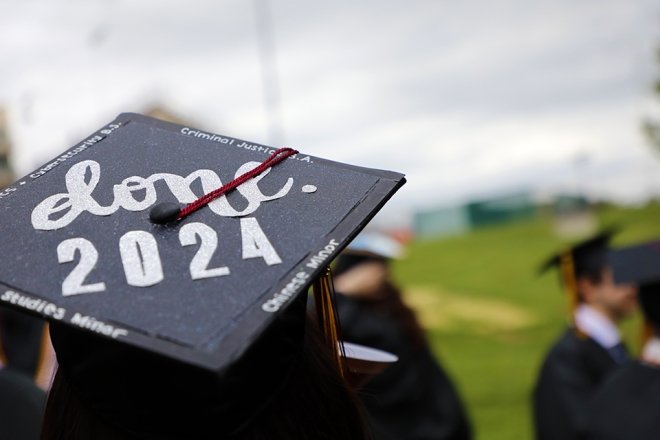 Graduate walks to the stadium for spring commencement at Commonwealth University-Bloomsburg, formerly Bloomsburg University