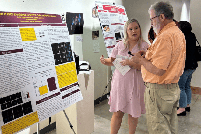 A student speaks with Terry Tressler '77 at the annual COHST Research Day