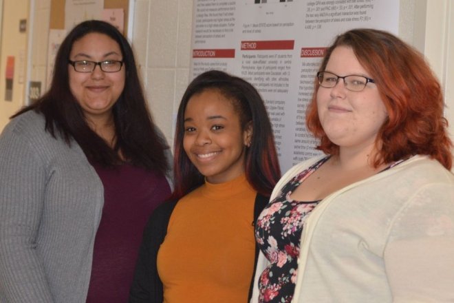 Three Psychology students from CU-Lock Haven in front of the research poster they presented