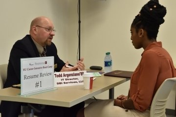 Two people sitting across from each other at a table.