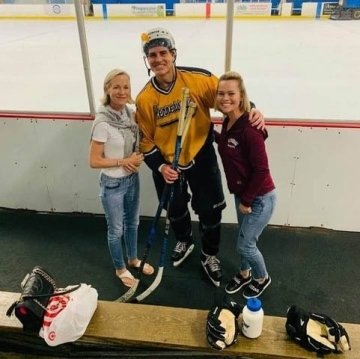 A group of three at a hockey rink.