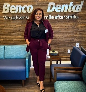 A girl standing in front of a Benco Dental sign. 