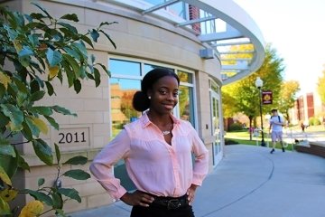 A girl standing in front of a building. 