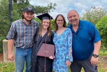 Four people standing side by side.