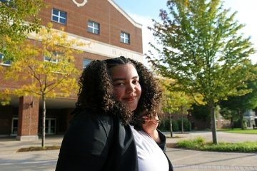 A girl standing in front of a building. 