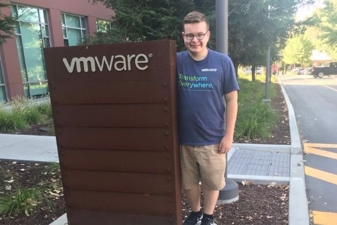 A man standing next to a VMware sign. 