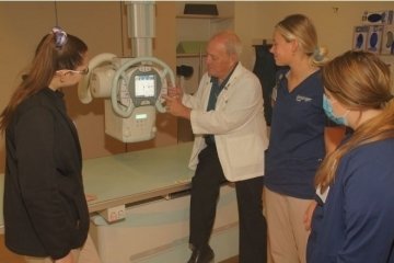 A group of people moving and looking at an x-ray tube. 