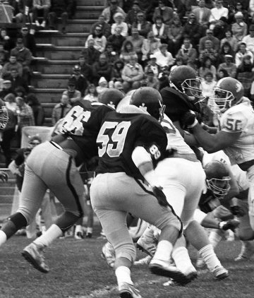 A black and white photo of a group playing football.