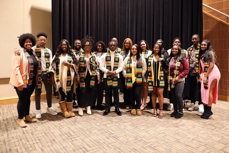 Group standing side by side for a photo. 