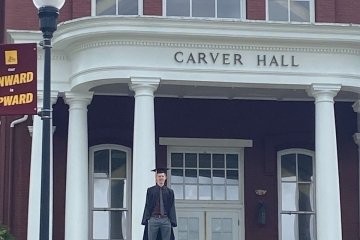 A man standing in front of a building. 