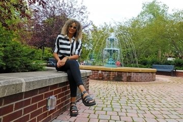 A girl sitting on a ledge. 