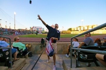 A man in the stands of a baseball field.