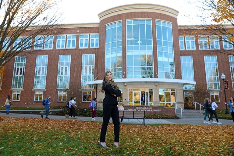 Student pictured in front of Terry and Joann Ziegler College of Business