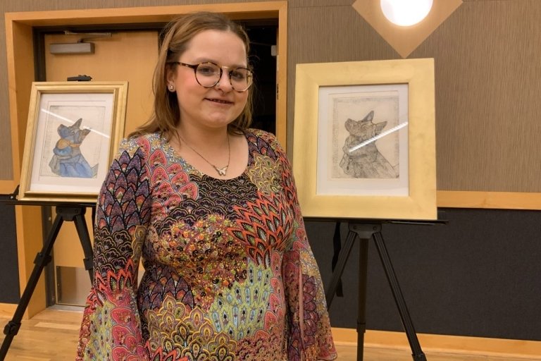 A girl standing with a picture. 