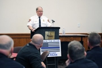 A police officer standing behind a podium. 