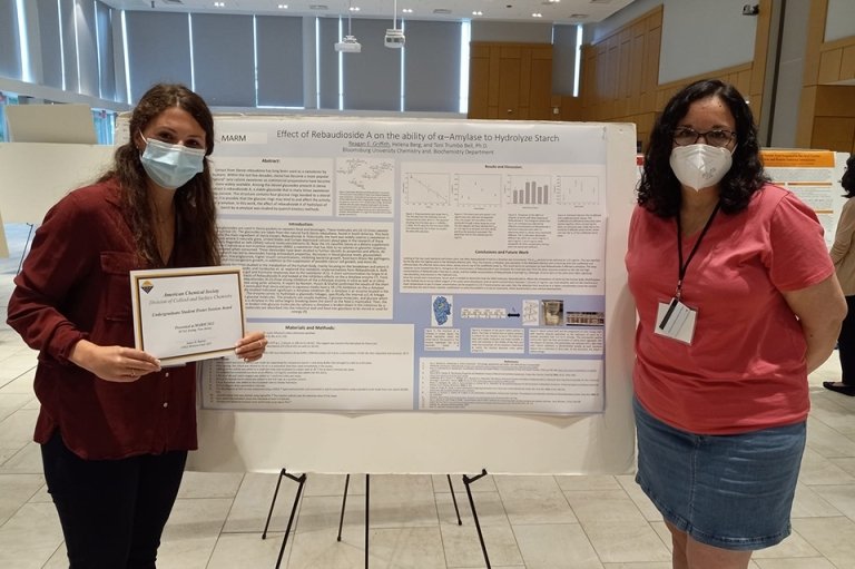 Two girls standing next to an information board. 