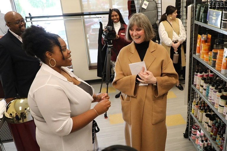 Stephenson pictured talking to a lady wearing a brown coat, with a photographer, a male, and a female in the background.