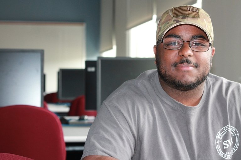 A headshot of a man in a computer lab. 