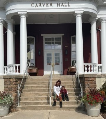 A girl and a little kid sitting on steps. 