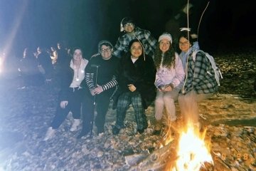 A group photo with a fire. 