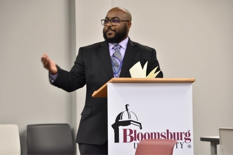 A man speaking from behind a podium. 