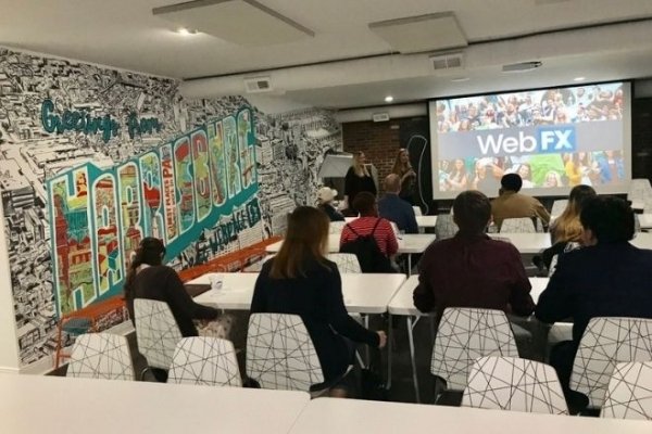 A group of people looking at a smart board. 