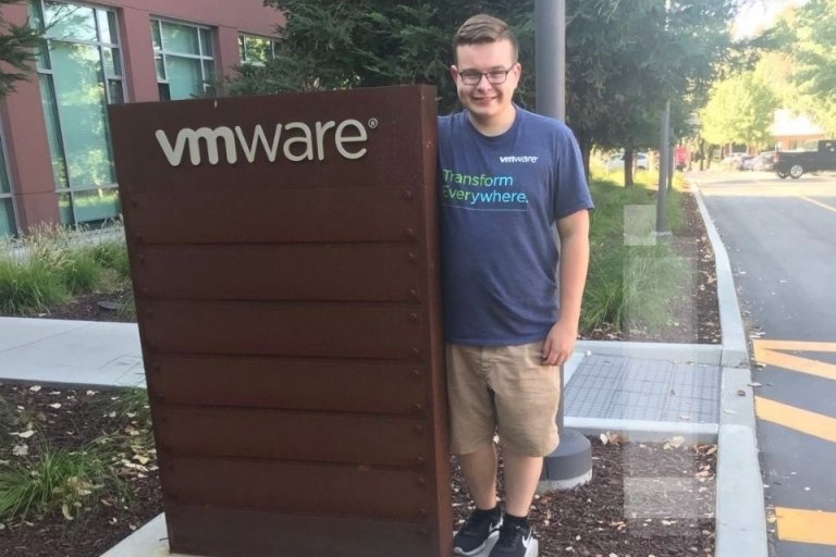 A man standing next to a VMWARE sign.