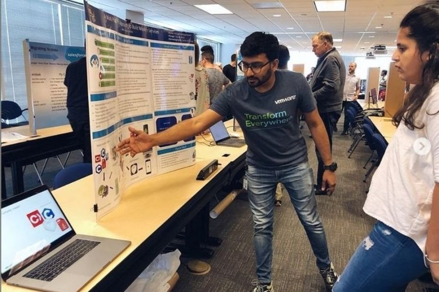 A man looking at an information board and a computer. 