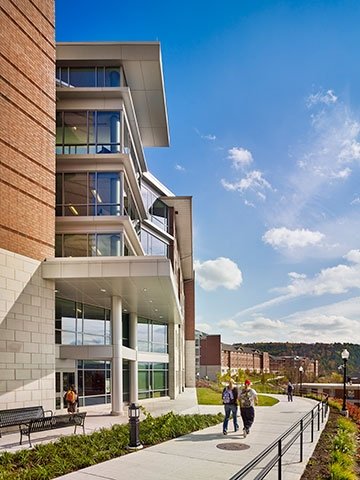 Mansfield students walking on path outside of residence hall.