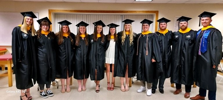 A group of students standing together in their caps and gowns. 