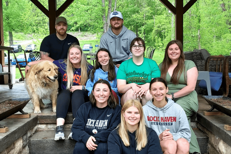 A group of people and a dog sitting together for a photo. 