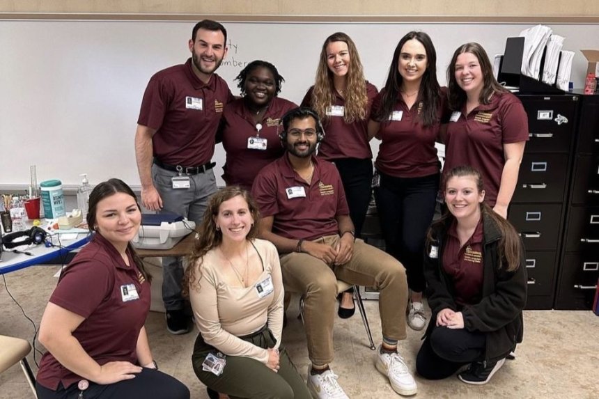 Audiology students taking a group photo in a school