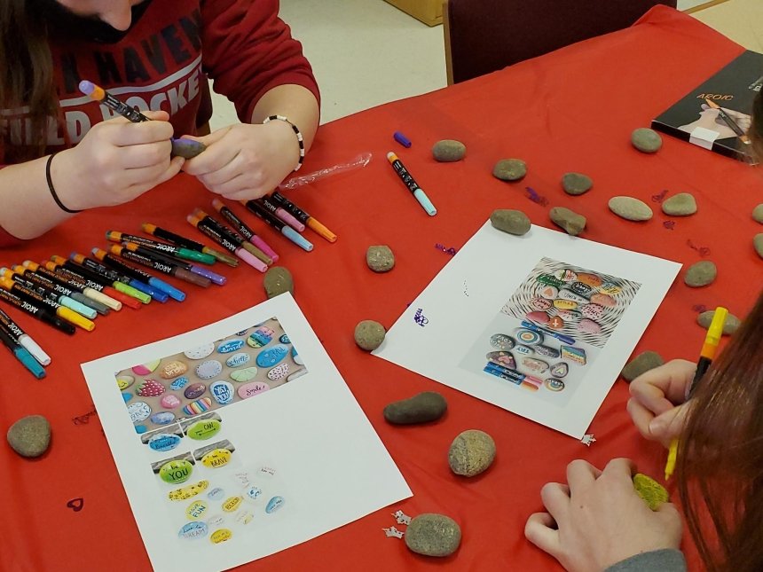 Two people sitting at a table coloring. 