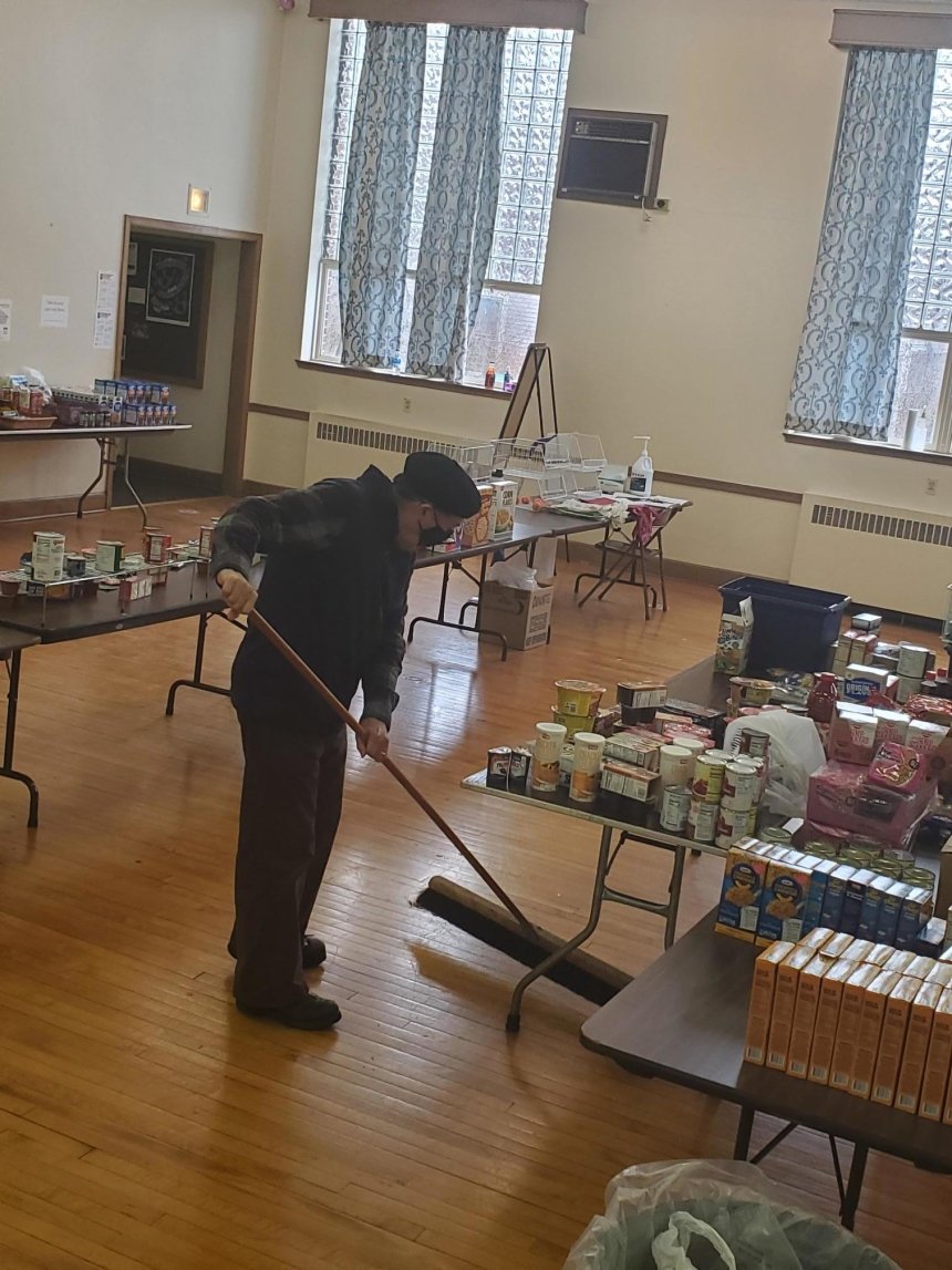 A guy sweeping the floor. 