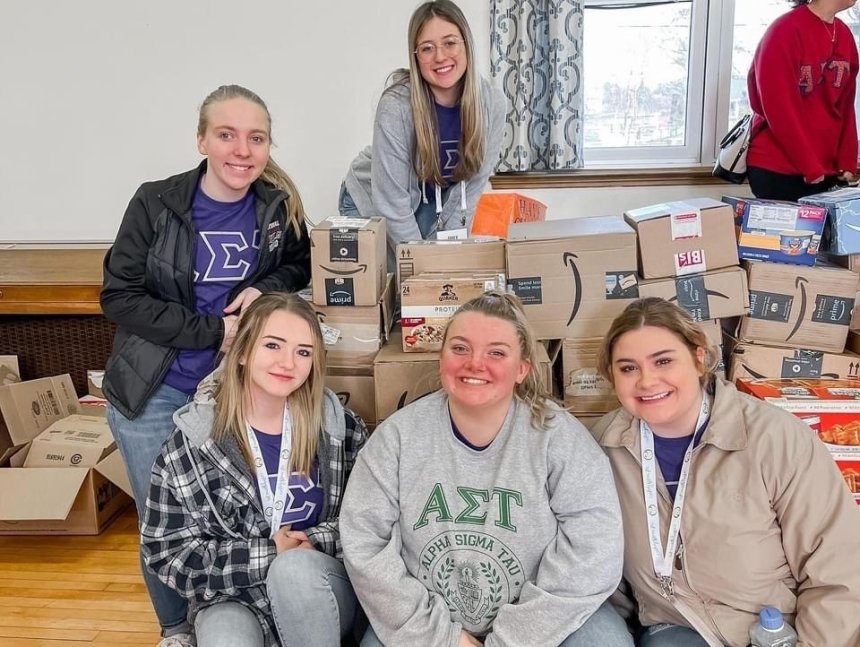 A group of people sitting around boxes. 