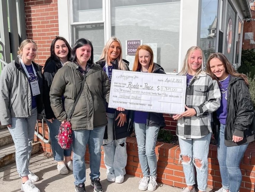 A group of people holding a large check. 