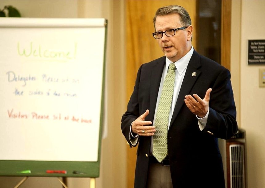 A man standing next to a whiteboard. 