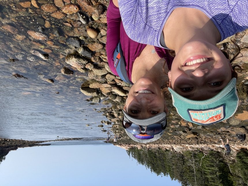 Two women in front of a lake. 