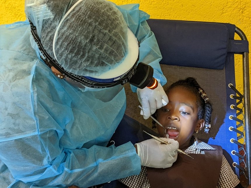 A kid getting their teeth cleaned. 