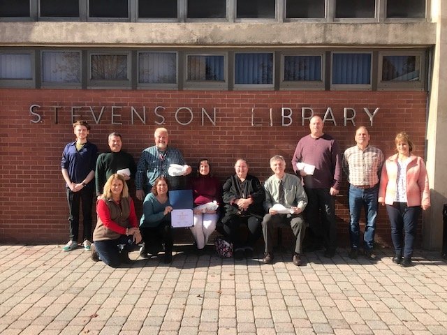 A group standing in front of a library. 