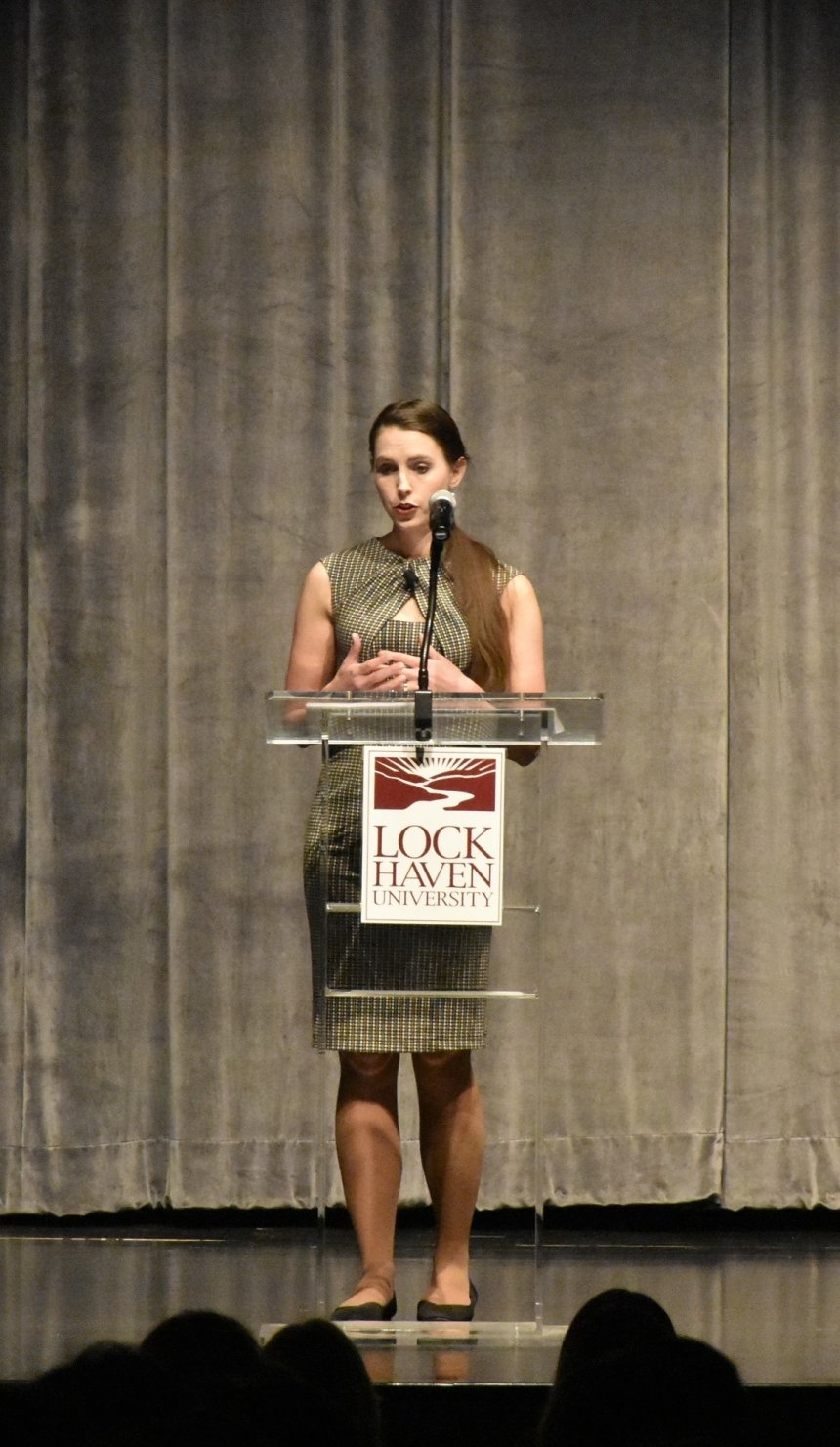 Rachael Denhollander standing behind a podium.