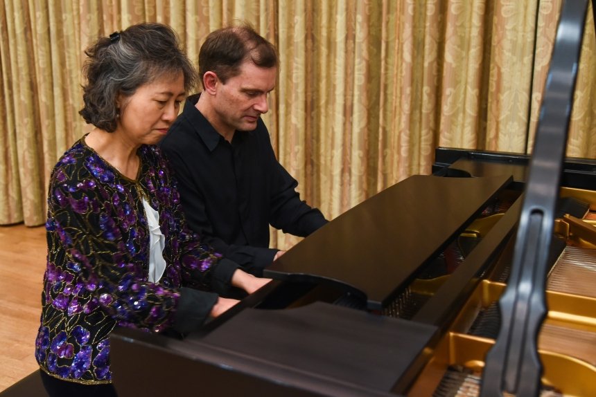 Two people playing piano. 